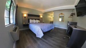 une chambre d'hôtel avec un lit et une télévision dans l'établissement Monterey Oceanside Inn, à Monterey
