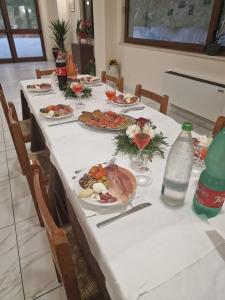 einen langen Tisch mit Teller mit Lebensmitteln drauf in der Unterkunft Agriturismo Pavoni in Castelliri