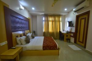 a bedroom with a large bed in a room at Hotel Royal Highness in Tinsukia +46 photos