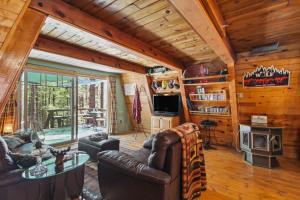 ein Wohnzimmer mit Ledermöbeln und einem großen Fenster in der Unterkunft Tranquil Forest Lakes Retreat Yard, Deck and Gazebo in Forest Lakes Estates