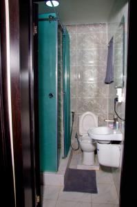 y baño con ducha, aseo y lavamanos. en NO 95 SUITES VI en Lagos