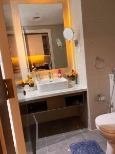 bagno con lavandino, servizi igienici e specchio di Nice studio with panoramic view of the Canal! a Dubai