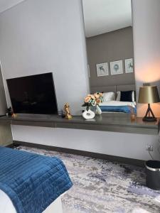 a bedroom with a bed and a flat screen tv at Nice studio with panoramic view of the Canal! in Dubai