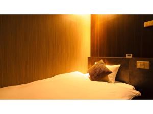 a bedroom with a bed with white sheets and pillows at Hotel AreaOne Minamisoma - Vacation STAY 56229v in Minamisouma +53 photos