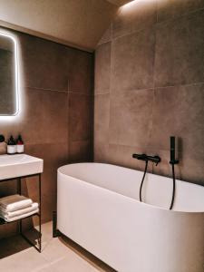 a bathroom with a white tub and a sink at Hotel Noreg in Ålesund