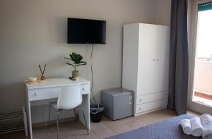 a bedroom with a desk and a tv on a wall at Mirage Mer B&B in Catania