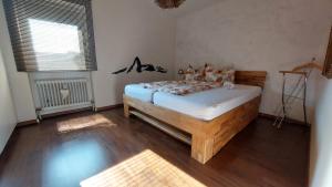 ein Schlafzimmer mit einem Bett in einem Zimmer mit Holzböden in der Unterkunft Ferienwohnung sunset Weissenstadt in Weißenstadt