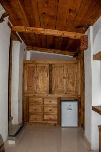 圣克里斯托瓦尔-德拉斯卡萨斯Hotel Real del Carmen - Ideal para familias y parejas的客房设有木制橱柜和白色冰箱。