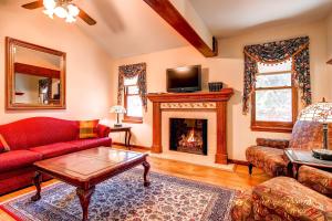 - un salon avec un canapé rouge et une cheminée dans l'établissement Adorable Victorian Style Townhome - Downtown Gem in Breckenridge Historic District VGE, à Breckenridge