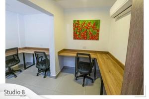 einen Tagungsraum mit 3 Stühlen und einem Tisch mit einem Gemälde in der Unterkunft Studio8 Lujan Apartament #8 in San José