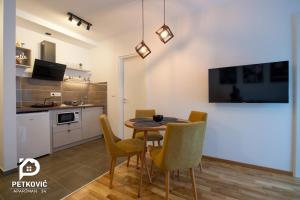 Petković apartmani 34 في ياغودينا: مطبخ وغرفة طعام مع طاولة وكراسي