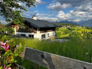 a house in the middle of a field with a fence at Haus Bergfeld with the view over Dachstein in Ramsau am Dachstein
