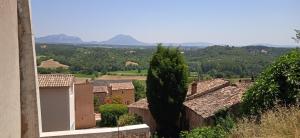 - une vue sur un village avec des montagnes en arrière-plan dans l'établissement Maison de village en Provence, à Puimoisson