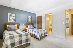 2 camas en una habitación con paredes azules en Cozy Winter Park Condo Bike, Ski, and Hike!, en Winter Park