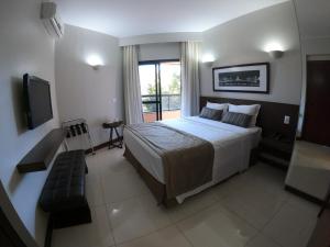 a bedroom with a large bed and a television at Bonaparte Excelente Apartamento #503 in Brasilia