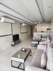 un grand salon avec des canapés et une télévision dans l'établissement المهيدب للوحدات السكنيه -رابغ, à Rabigh