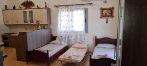 a small room with two beds and a window at Vila Horizont Ksamil in Sarandë