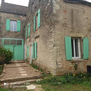 an old brick building with green shutters on it at Gîte de la Rivière in Clamecy