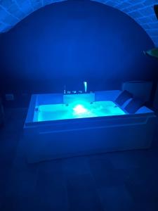 a dark room with a tub with a blue light at 2 Love rooms in Corato