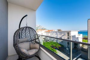 una silla colgante en un balcón con vistas al océano en New Apartment White Angel, en Duće