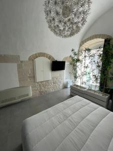 a bedroom with a large bed and a chandelier at 2 Love rooms in Corato