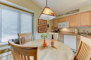 a kitchen with a wooden table with chairs and a dining room at Cozy Country Lakeside Condo 5705 in Traverse City