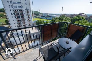 einen Balkon mit einem Tisch und Stühlen sowie ein Gebäude in der Unterkunft Petković apartmani 34 in Jagodina