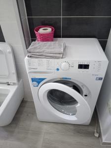 - un lave-linge blanc dans la salle de bains pourvue de toilettes dans l'établissement New Apartment, à Petroşani