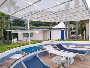 卡帕喬－帕埃斯圖姆的住宿－Camera Vista Capri，一个带桌椅的游泳池上的白色天篷