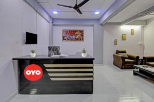 eine Lobby mit einem Schreibtisch mit Fernseher und einer Couch in der Unterkunft Hotel O Happy Stay in Méribel Village