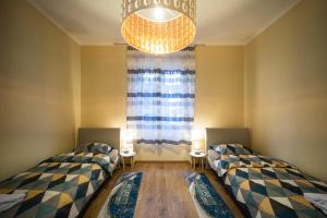 Duas camas num quarto com uma janela e um lustre em Brunea em Rijeka