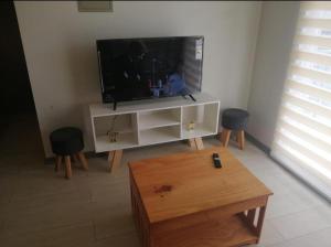een woonkamer met een flatscreen-tv en een salontafel bij Departamento en Pucón 202 in Pucón