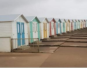 a row of colorful beach houses in a row at 20 The Manor, Penstowe Holiday Park, Kilkhampton BUDE in Kilkhampton
