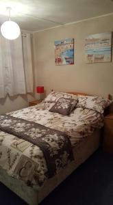 a bedroom with a bed with a comforter on it at 20 The Manor, Penstowe Holiday Park, Kilkhampton BUDE in Kilkhampton