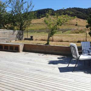 2 sedie bianche sedute su una terrazza di legno di Lavender Row Farm 