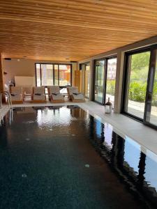 a house with a swimming pool with chairs and windows at La Sura Germain 
