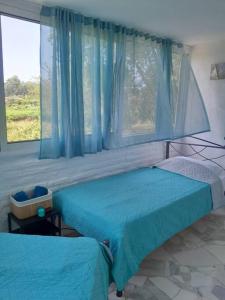 a bedroom with two beds and a window at Stefanos' Art House in Halikounas