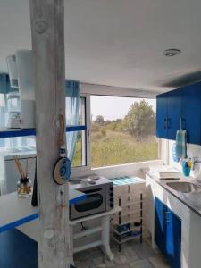 a small kitchen with blue cabinets and a window at Stefanos' Art House in Halikounas