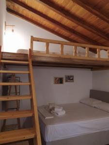ein Schlafzimmer mit einem Etagenbett und einer Leiter in der Unterkunft LIMENARI COTTAGE in Kechria