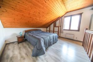 1 dormitorio con 1 cama en una habitación con techo de madera en Charmant T2 spacieux au pied de Montdauphin, en Eygliers