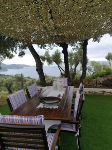 a wooden table and chairs under an umbrella at LIMENARI COTTAGE in Kechria