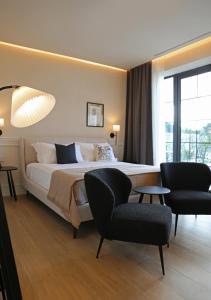 ein Hotelzimmer mit einem Bett und zwei Stühlen in der Unterkunft Salento Winery Lodge in San Pietro in Bevagna
