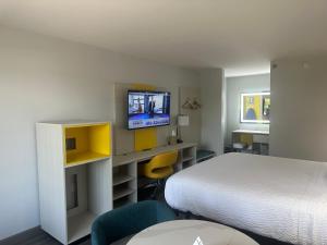 a hotel room with a bed and a tv on a wall at Days-Inn by Wyndham Baltimore Northwest in Baltimore