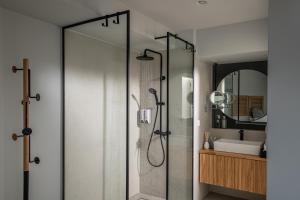 a bathroom with a shower with a glass door at Beachfront Salty Sea Luxury Suite 2 in Agios Nikolaos