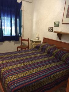 - une chambre avec un lit doté d'une couverture rayée dans l'établissement Renata, à Formia