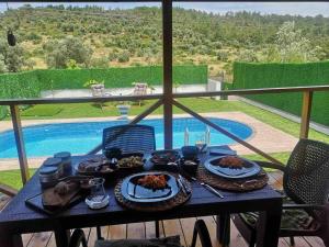 un tavolo con cibo e vista sulla piscina di Hakuna Matata Tiny House Urla / Özel Havuzlu 