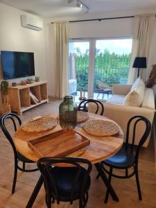 ein Wohnzimmer mit einem Holztisch und Stühlen in der Unterkunft Apartament FOREST - HOME APART in Ostróda
