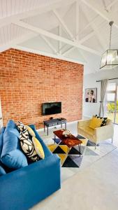 a living room with a blue couch and a brick wall at Stylish Loft Style Apartment in Durban