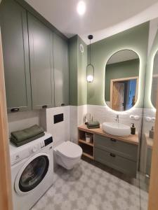 a bathroom with a washing machine and a sink at Apartament FOREST - HOME APART in Ostróda