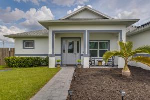 a house with a palm tree in the front yard at Port Saint Lucie Vacation Rental with Hot Tub! in Port Saint Lucie
